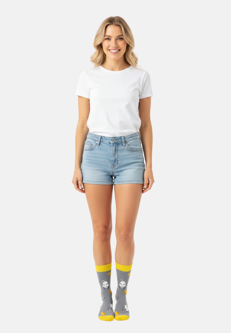Weißes T-Shirt mit kurzen Ärmeln, hellblaue Jeansshorts und graue Socken mit gelben Akzenten und verspielten Geistermustern.