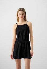 Svart lin romper med spaghetti-stropper, elastisk midje og løstsittende shorts. Glatt tekstur, minimalistisk design uten mønstre.