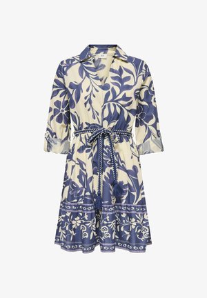 Kreemja ja sinise lillemustriga kleit, millel on 3/4 varrukad, krae ja punutud vöö, millel on sabad, seotuna vöökohal.