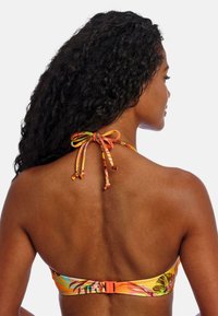 Top de bikini con coloridos patrones tropicales, tirantes ajustables con un detalle de lazo en la parte posterior y un cierre sólido de color naranja.