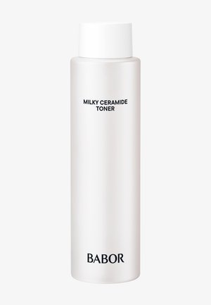 Grande bouteille blanche avec bouchon blanc étiquetée « Milky Ceramide Toner » et nom de la marque « BABOR » en bas sur un fond uni.