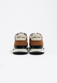 Brązowo-czarne trampki z zamszową i siateczkową cholewką, z białym logo na pięcie i grubą czarną podeszwą.