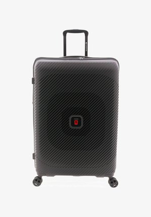 Valise rigide noire avec rainures diagonales, logo carré central, quatre roues pivotantes et poignée télescopique prolongée.