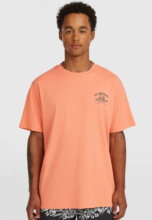 Tričko s krátkym rukávom v koralovej farbe vyrobené z bavlny, s malým čiernym logom na ľavej strane hrudníka. Rovný lem, voľný strih.