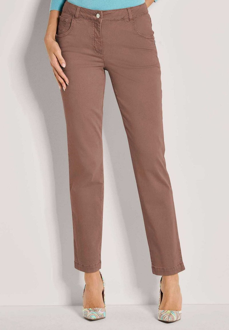 Bruine katoenen broek met een slim fit, voorzien van een sluiting met een knoop aan de voorkant, ceintuurlussen en twee voorzakken. Draagt een patroon op hoge hakken.