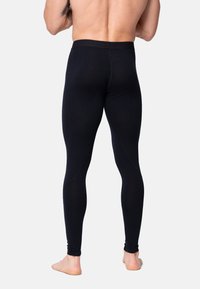 Sorte kompressionsleggings lavet af strækbart materiale med en glat tekstur og et tætsiddende design, der fremhæver benene.