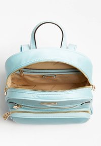 Jasnoniebieski skórzany plecak o gładkiej powierzchni, z dwoma zamkami błyskawicznymi, dwoma kieszeniami wewnętrznymi i złotym akcentem w postaci elementów metalowych. Wnętrze w kolorze beżowym.