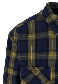 Kockás flaneling kék, zöld és sárga mintával. Gombos zsebbel és standard gallérral rendelkezik. Puha tapintású.