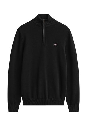 Schwarzer langärmeliger Strickpullover mit gerippten Bündchen und Saum, halbem Reißverschluss vorne und kleinem besticktem Logo auf der linken Brust.