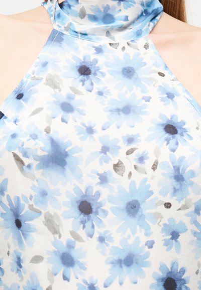 Κοντινό πλάνο ενός αμάνικου τοπ με λαιμόκοψη halter, με μπλε και γκρι λουλουδάτο σχέδιο σε λευκό φόντο.