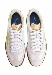 Sneakers bianchi con accenti in suede beige, strisce laterali verdi e suole in gomma marrone. Presentano lacci bianchi e un logo sulla linguetta.