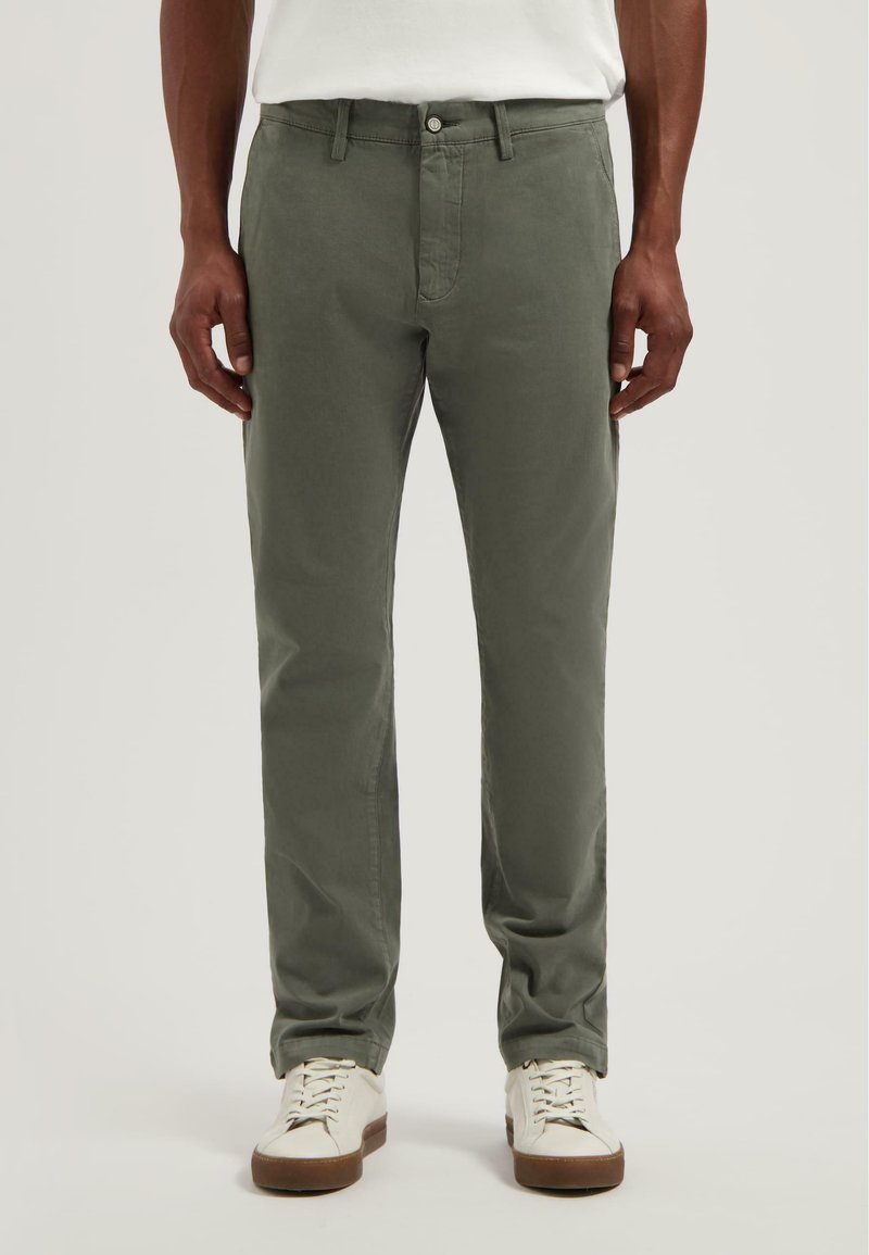 Olívazöld pamut nadrág, slim fit kivitelben, standard derékkal, elülső zsebekkel és kontrasztos fehér varrással.