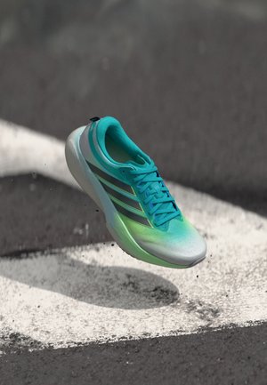 Scarpa sportiva in gradiente turchese e verde con design elegante, dotata di tomaia leggera e traspirante e tre strisce nere sul lato.