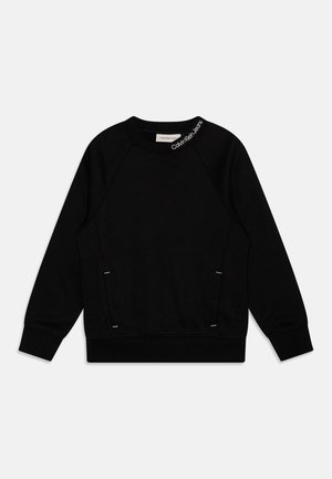 Sweat-shirt noir à manches longues, col rond, avec le logo Calvin Klein Jeans sur le col, présenté à plat sur fond blanc.