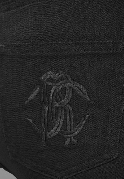 Jeans de mezclilla negros con un logo bordado negro en el bolsillo trasero, con un acabado texturizado y un sutil detalle de costura.