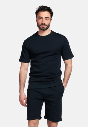 Donkerblauwe sweatshirt met korte mouwen en bijpassende shorts, gemaakt van zacht, structuurstof. Voorzien van een ronde hals en opgerolde mouwen.