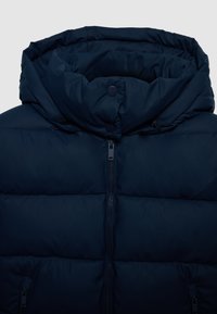 Giacca imbottita di colore blu scuro con colletto alto, cappuccio, zip frontale, bottoni a pressione e tasche laterali con zip.