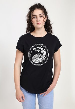Zwart T-shirt met korte mouwen, voorzien van een cirkelvormig wit grafisch ontwerp met golven en tekst in een gedurfde, moderne stijl. Gemaakt van zacht katoen.