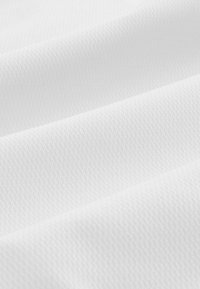 Baltas audinys su tekstūru, turintis subtilų deimanto raštą. Medžiaga atrodo minkšta ir lygi, su sulankstytais sluoksniais.