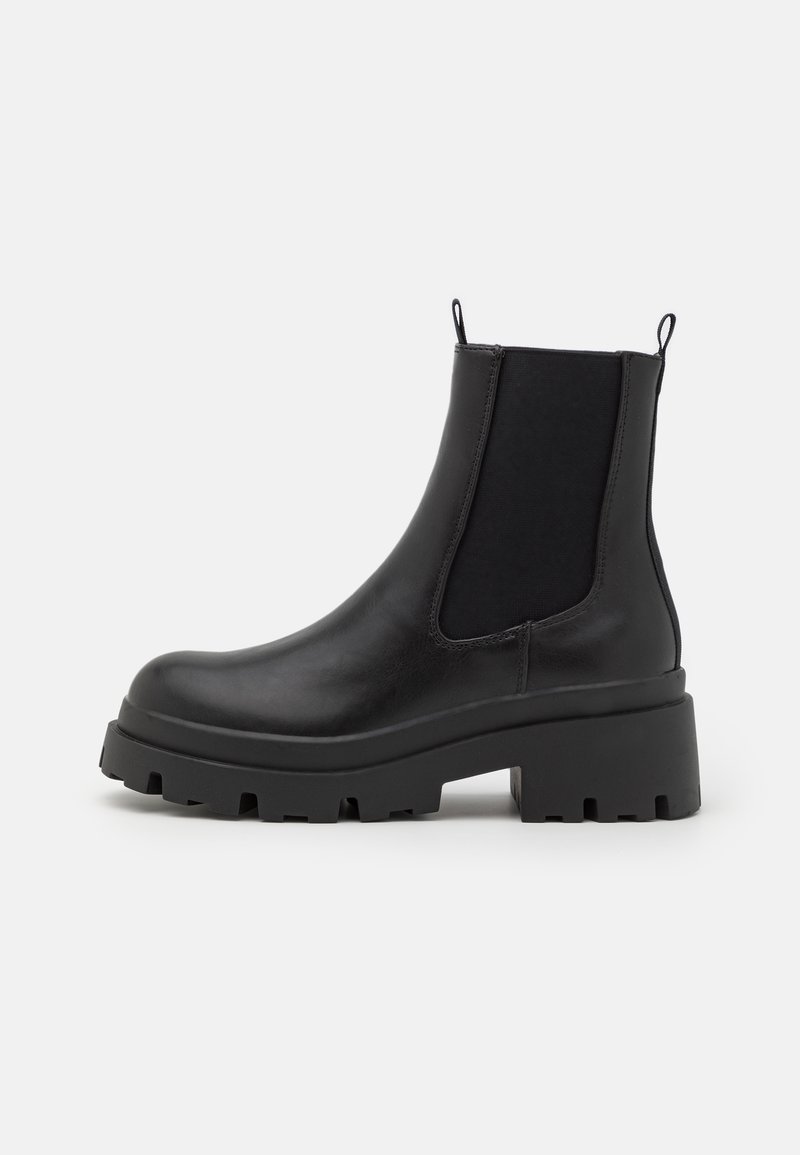 Schwarze Leder-Ankle-Boots mit elastischen Seitenpaneelen, kräftiger Profilsohle und Zugschlaufen. Glatte Oberfläche mit einem abgerundeten Design der Zehenpartie.