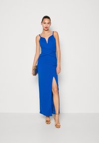 Μπλε, αμάνικο μάξι φόρεμα με βαθύ V-λαιμόκοψη και σχισμή στο πλάι; διαθέτει περιστρεφόμενο ύφασμα στη μέση; ομαλό, ελαστικό υλικό.