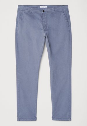 Világoskék pamut chinos nadrág, slim fit szabású, sima elülső résszel és két oldalsó zsebbel. Egy gombos záródással és övbújtatókkal rendelkezik.