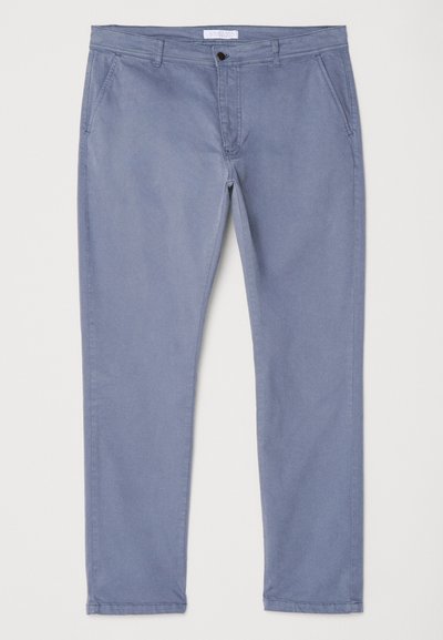 Lysblå bomulds chinos med slim fit, flad front og to sidelommer. Har en enkelt knaplukning og bæltestropper.