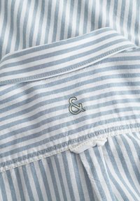 Camicia in cotone a righe con righe azzurro chiaro e bianche, colletto classico e logo ampersand ricamato sul retro.
