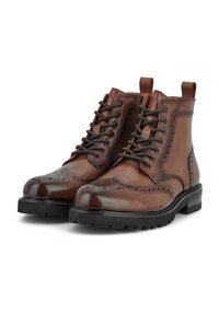 Brown leather ankle boots with brogue detailing, lace-up front, and black rubber sole. Features pull tab for easy wear.