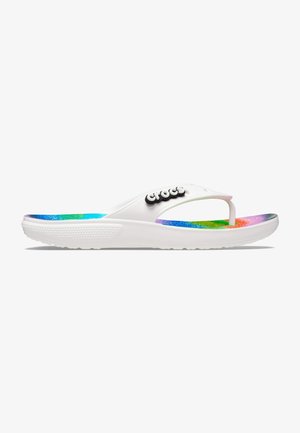 Tongs Crocs blanches avec une semelle intérieure texturée aux couleurs de l'arc-en-ciel et un logo Crocs noir et blanc sur la bride.