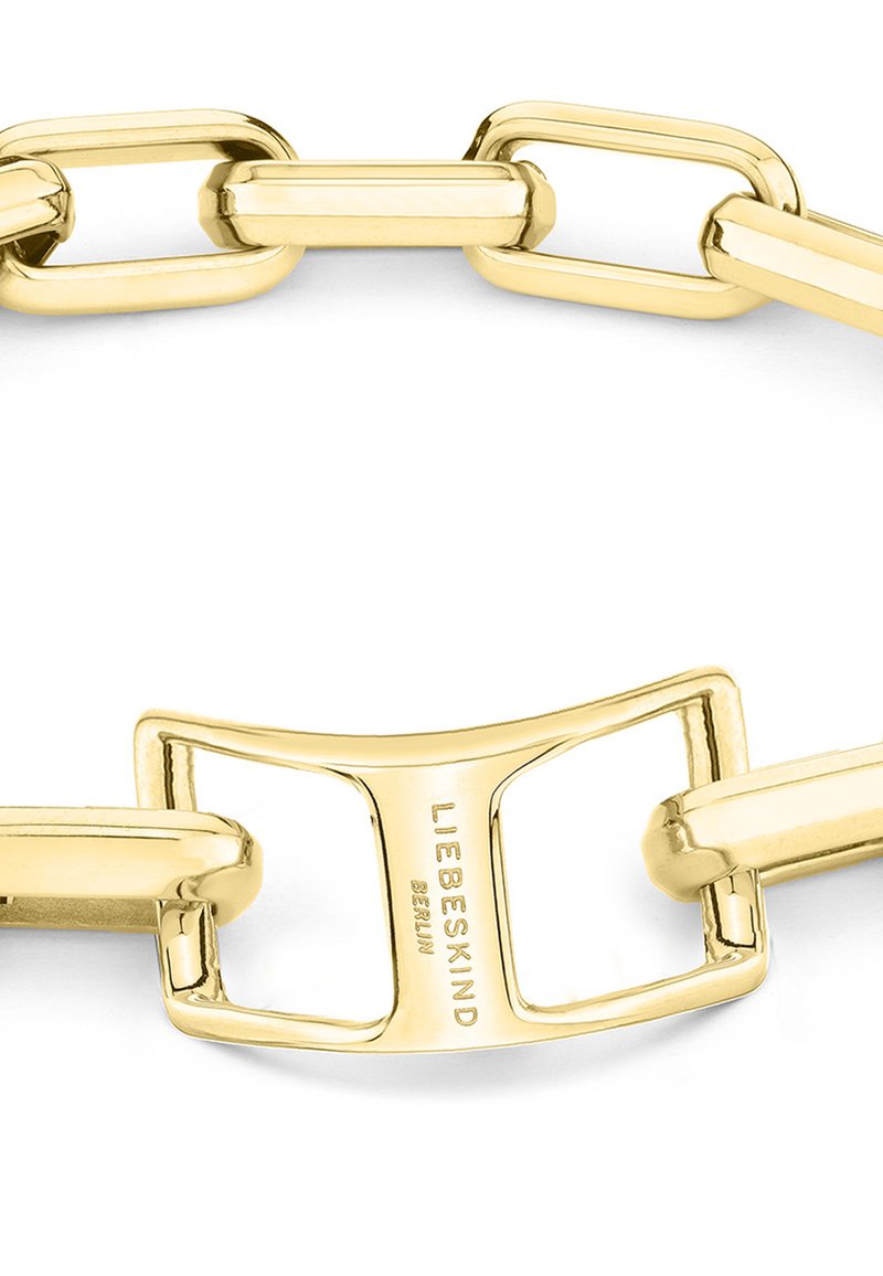 Gouden metalen schakelarmband met langwerpige schakels en een gepolijste afwerking. Opvallend detail: een sluiting met gegraveerd merk.