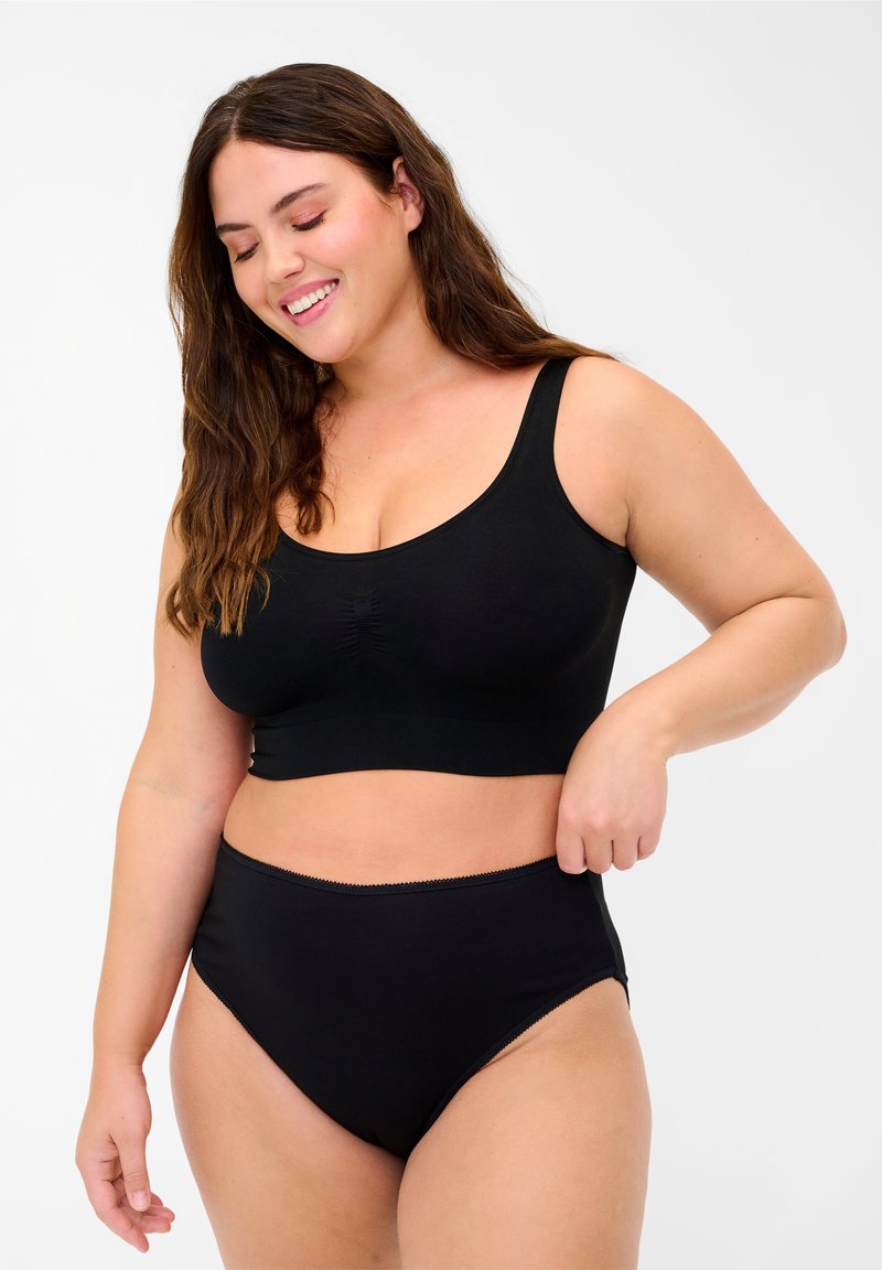 Black seamless bralette with wide straps and gathered front detail, paired with high-waisted black underwear featuring a smooth texture.
