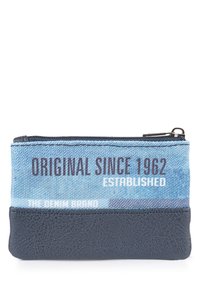 Cartera de denim con un frente de tela texturizada azul que presenta texto impreso y una base de cuero negro liso, asegurada con un cierre de cremallera plateado.