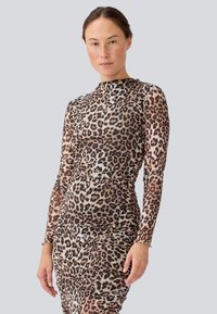 Robe à manches longues en imprimé léopard dans des nuances variées de marron, présentant un design ajusté et une texture froncée le long du corps et des manches.