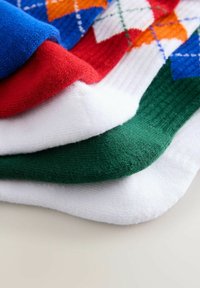Mehrfarbige Socken übereinander gestapelt: blau, rot, weiß und grün mit einer gerippten Textur und einem Argyle-Muster in Orange und Blau auf der obersten Socke.