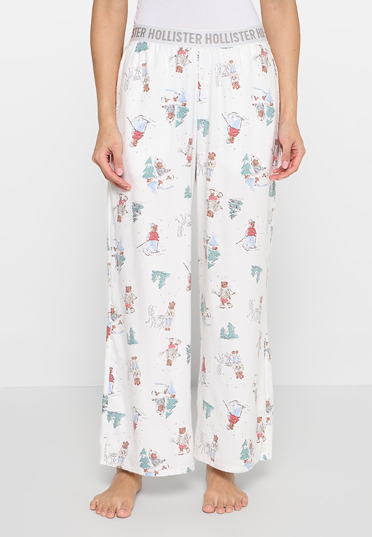 Weiße Pyjamahose mit verspieltem winterlichem Muster, das Tiere und Bäume zeigt, elastischem Bund und weitem Bein.