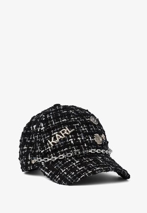 Casquette de baseball en tweed noir et blanc avec une chaîne argentée à l'avant, lettres métalliques "KARL" et épingles décoratives sur le dessus.