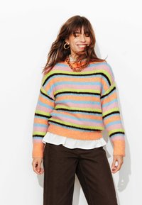 Pull rayé multicolore en matière douce et pelucheuse. Comprend des rayures orange, bleu pastel, rose, vert et noir. Encolure ronde et poignets côtelés.