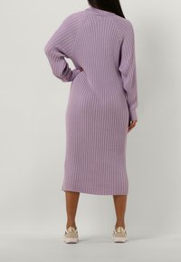 Robe en maille lavande douce avec texture côtelée, manches longues et longueur mi-mollet. Dotée d'un col montant et d'une coupe décontractée.
