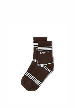 Braune Socken bis zur Mitte der Wade mit weißen und schwarzen Streifen und dem Schriftzug "10DAYS" am Bündchen.