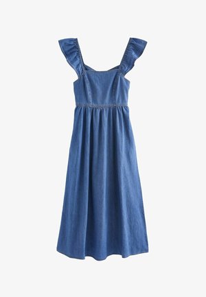 Gros plan sur une personne portant une robe en jean bleue sans manches avec des bretelles volantées aux épaules et un décolleté carré.