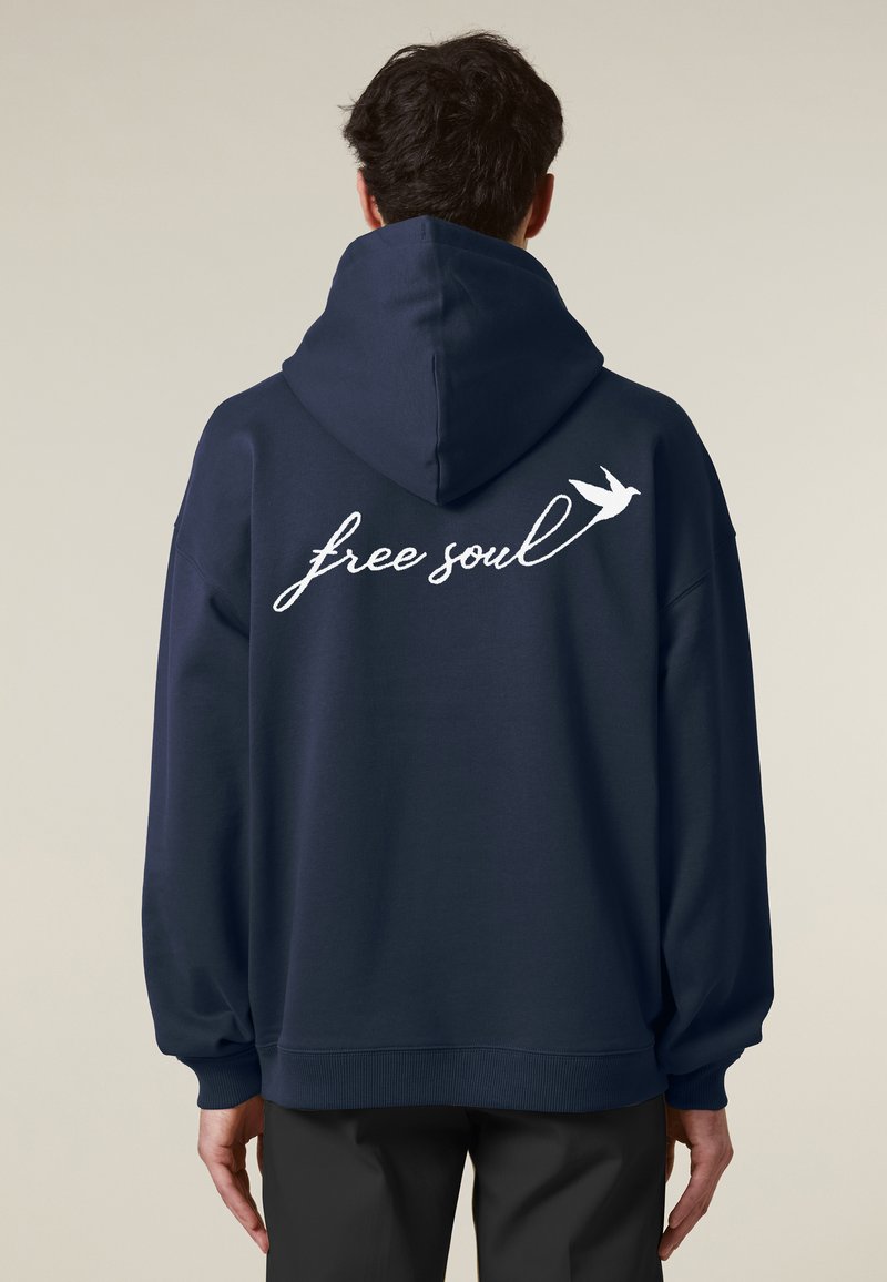 Sweat-shirt à capuche bleu marine avec une coupe décontractée, présentant un texte en blanc en cursive "free soul" et un petit graphique d'oiseau dans le dos.