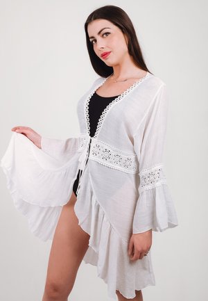 Copertura in stile kimono bianca e trasparente con maniche svasate, orlo a scallop e dettagli in crochet lungo il collo e in vita.