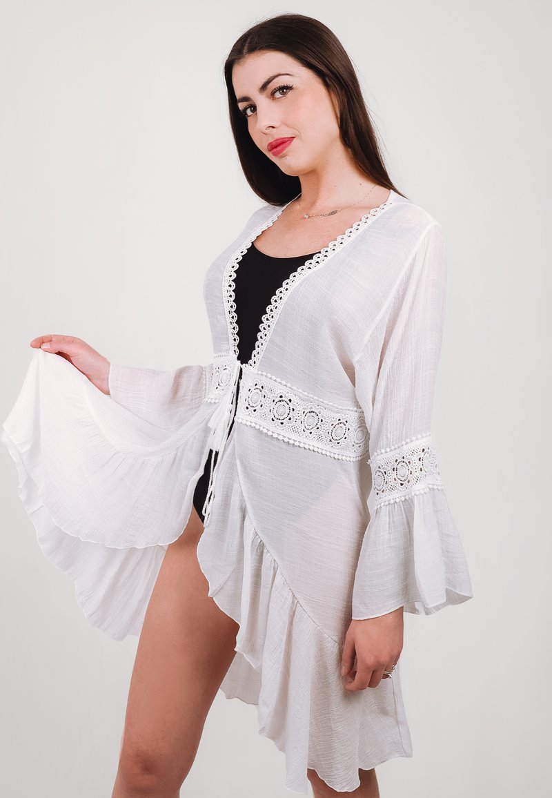 Copertura in stile kimono bianca e trasparente con maniche svasate, orlo a scallop e dettagli in crochet lungo il collo e in vita.