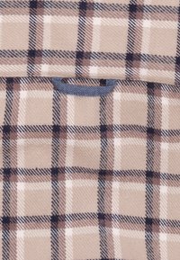 Beige geruite stof met donkerblauwe en bruine controlepatronen. Inclusief een marineblauwe handgreep detail in het midden bovenaan.