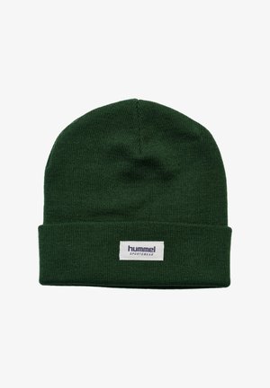 Ciemnozielona dziana czapka z wywiniętym mankietem, z białą prostokątną metką z logo "hummel SPORTSWEAR" wyhaftowanym na niej.