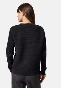 Strickpullover in Schwarz mit einem strukturierten Rippmuster, langen Ärmeln und einem schlichten runden Ausschnitt, entworfen für eine legere Passform.