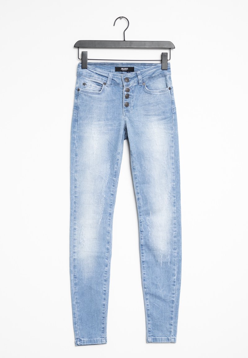 Jean skinny en denim bleu clair avec un effet délavé, cinq poches et une braguette à boutons. Suspendu sur un cintre en plastique noir sur un fond blanc.