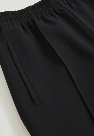 Zwarte joggers met een elastische tailleband, voorzien van een gladde textuur en zijzakken geïntegreerd in de naad. Minimalistisch ontwerp, lichtgewicht stof.