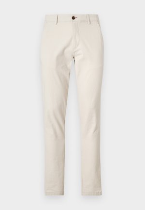 Béžové bavlněné kalhoty slim fit, s předními kapsami a jedním hnědým knoflíkem na zavírání v pase. Hladká textura.